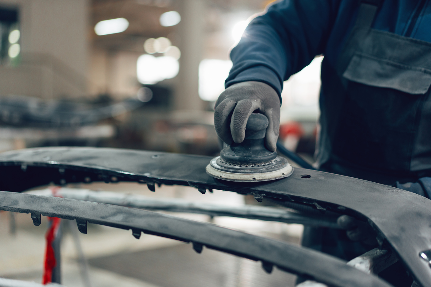 Auto mechanic straightening car body in car service station